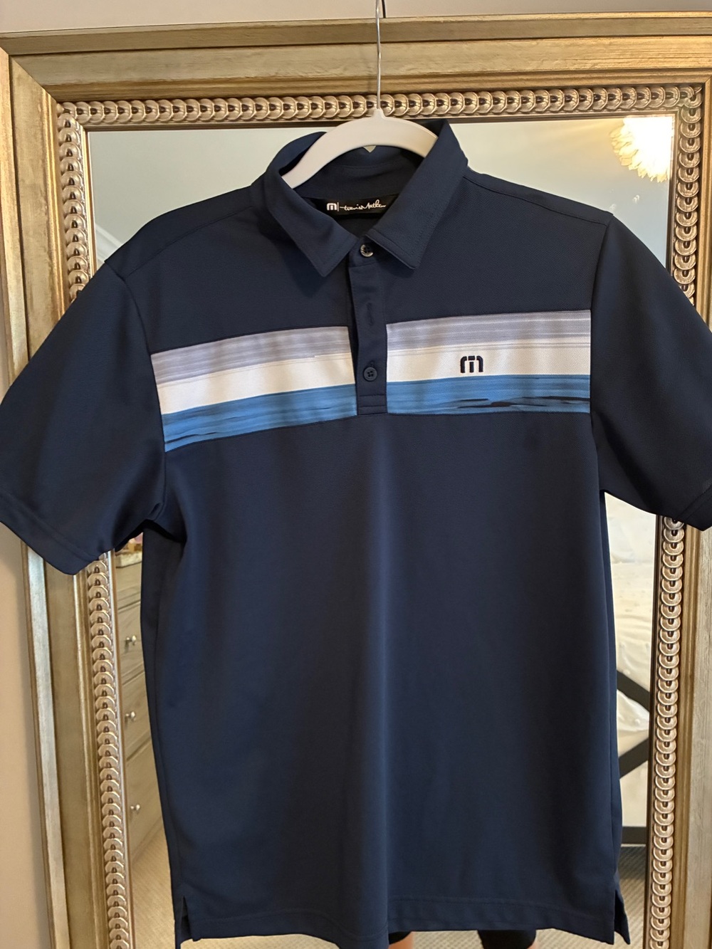 Travis Mathew’s  Men's Performance Navy Polo with Blue Stripe